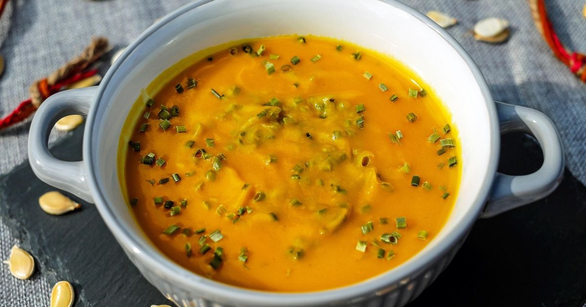 Bowl of classic pastina soup with tiny pasta stars in golden chicken broth, garnished with parsley and Parmesan cheese